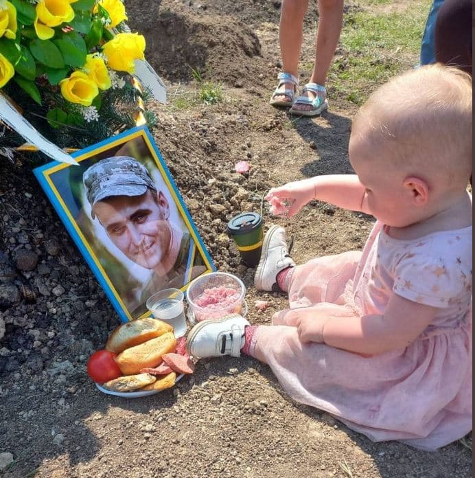 Fotoja simbol/ Vogëlushja ukrainase feston ditëlindjen mbi varrin e të atit të vrarë në luftë