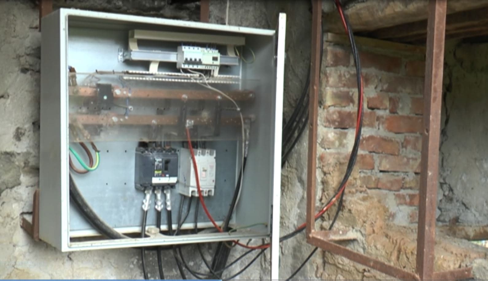 Rregullonte kabinën elektrike, një person në Mat e zë korrenti