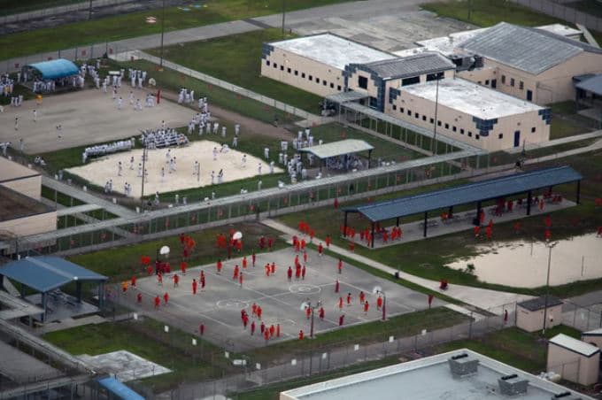 Emigrantët në burgun e Miamit u detyruan të gjunjëzoheshin për të ngrënë “si qenë”